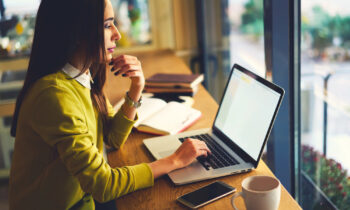 A woman looking for a nonprofit work from home job on her laptop