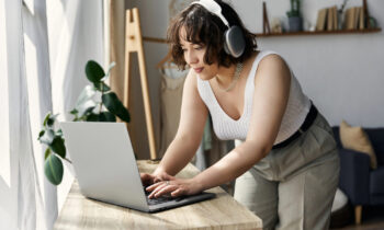 A woman working from home on her laptop reading a review on Apple work from home jobs