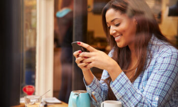 A young female sitting a a cafe getting paid to text