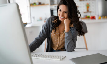 A young female working on her laptop reading an article about remote jobs with unlimited PTO