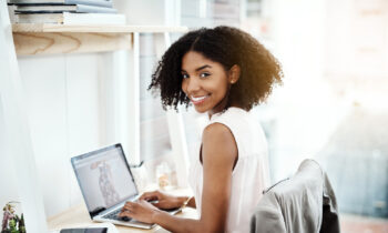A young woman working on her laptop looking for online editing jobs