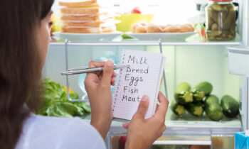 woman making a grocery list and meal planning for the week