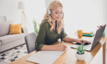 A middle aged woman working on her laptop completing work for her typing job