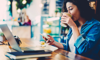 Woman searching on phone for jobs that pay $19 per hour while drinking coffee