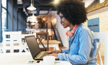 Young woman working in a cafe on her laptop as a search engine evaluator